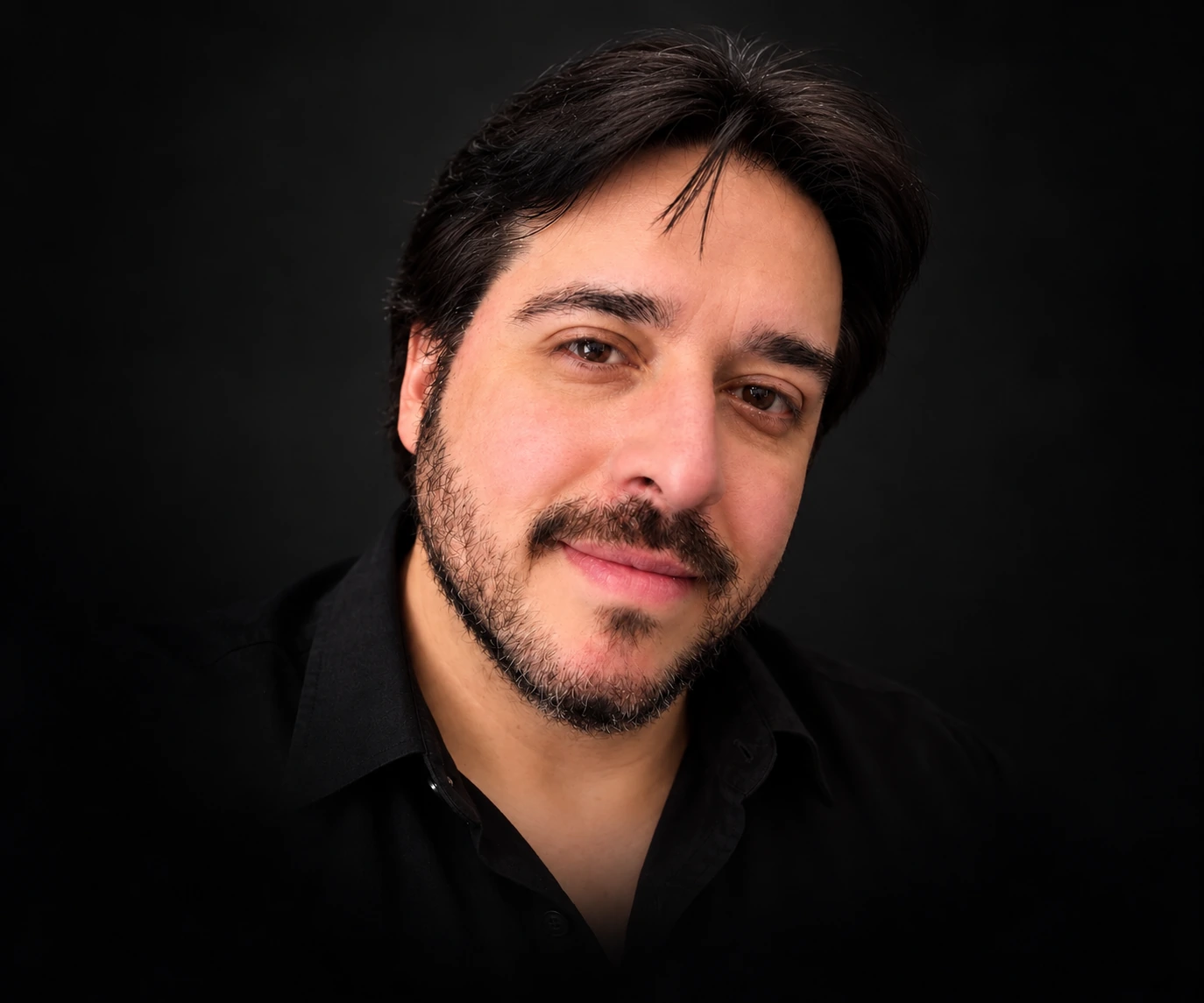 Jorge Beraun, wearing a black shirt, against a dark background.